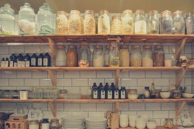 Wooden shelves in a kitchen with glass storage jars