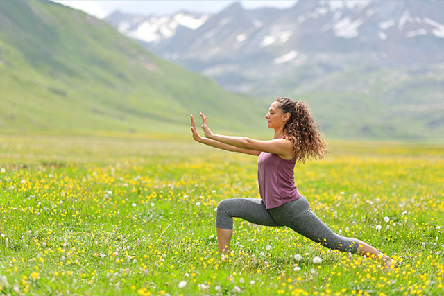 Woman doing yoga in a field
