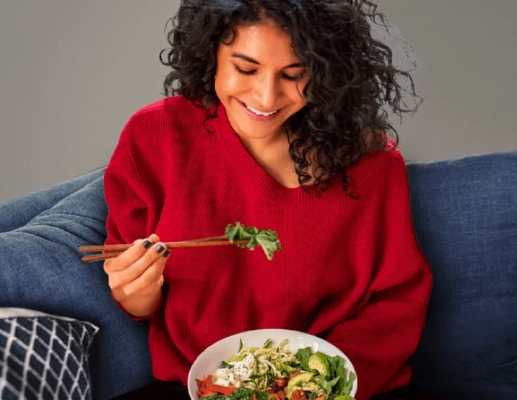 Woman smiling eating a salad